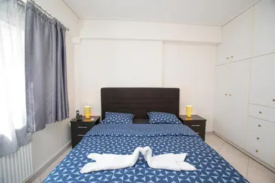 a bedroom with a bed with two white towels on it at illusion 1 in Piraeus