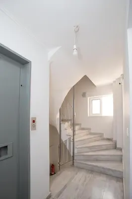 a staircase in a house with white walls and wooden floors at illusion 1 in Piraeus