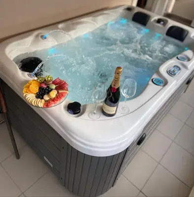 a hot tub with a bottle of champagne and wine glasses at illusion 1 in Piraeus