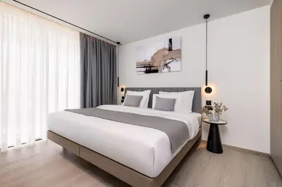 a bedroom with a large white bed and a large window at Urban K in Athens