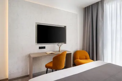a hotel room with a bed and a tv on a wall at Urban K in Athens