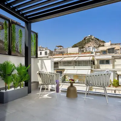a balcony with two chairs and a table on a building at Urban K in Athens