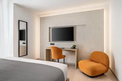 a bedroom with a bed and a desk and a tv at Urban K in Athens