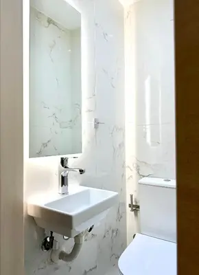 a white bathroom with a sink and a toilet at Casa Marina in Athens