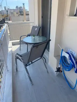 a table and chairs on a balcony with a window at City apartment in Athens