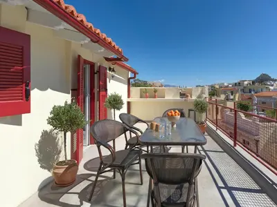a patio with a table and chairs on a balcony at The Acropolis Window in Athens