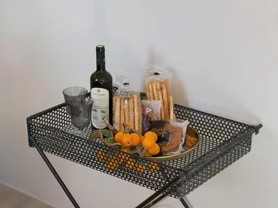 a black wire shelf with a plate of food and wine at The Acropolis Window in Athens