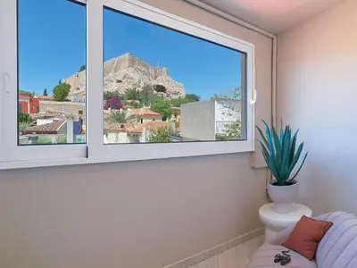 a window in a living room with a potted plant at The Acropolis Window in Athens