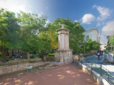 a monument in a park next to a fence at The Acropolis Window in Athens