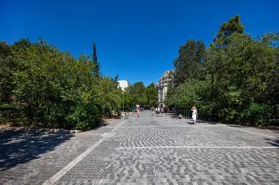 a cobblestone street with people walking on it at The Acropolis Window in Athens