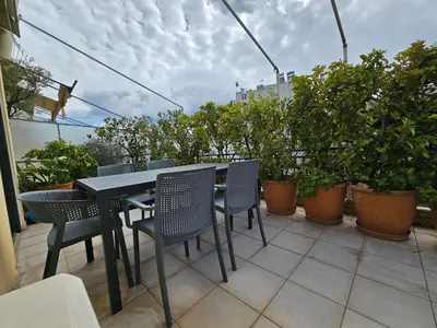 a black table and chairs on a balcony with plants at Ilissos Terrace Apartment in Athens
