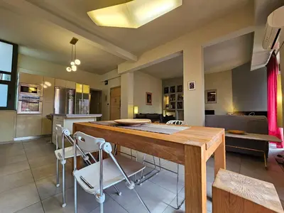 a kitchen and dining room with a wooden table and chairs at Ilissos Terrace Apartment in Athens