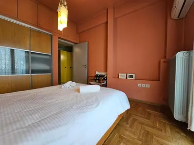 a bedroom with a large bed with orange walls at Ilissos Terrace Apartment in Athens