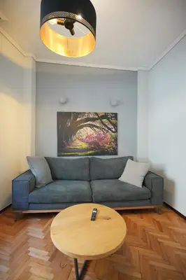 a living room with a blue couch and a table at Cozy Exarcheia, 1 BDRM central Apartment in Athens