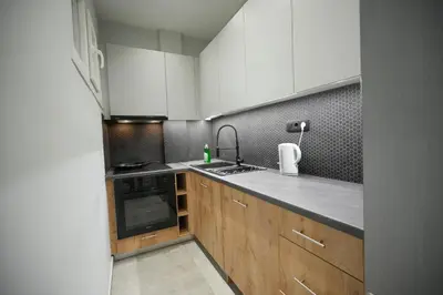 a kitchen with wooden cabinets and a sink and a stove at Cozy Exarcheia, 1 BDRM central Apartment in Athens