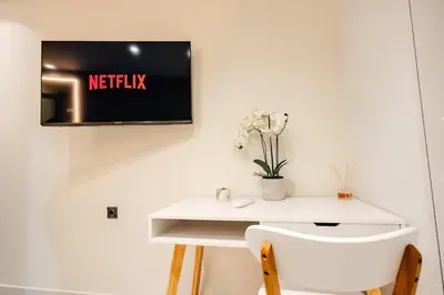 a white desk with a tv on a wall at Sunset luxury studio by the sea in Athens