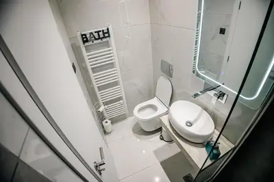 a bathroom with a white toilet and a sink at Sunset luxury studio by the sea in Athens