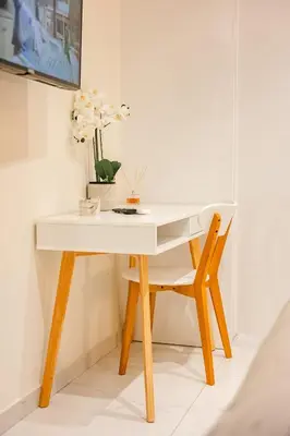 a white desk with a chair and a vase of flowers at Sunset luxury studio by the sea in Athens