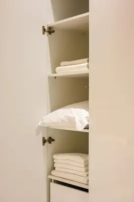 a closet with white towels on the shelves at Sunset luxury studio by the sea in Athens