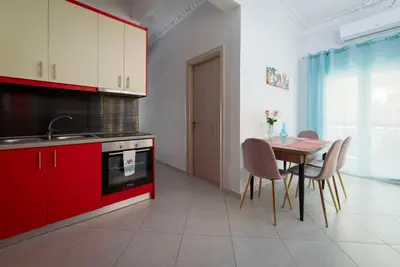 a kitchen with red cabinets and a table and chairs at Cuka apartment 3BD nexto to metro and Piraeus Port in Piraeus