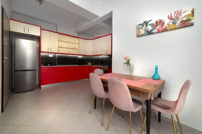 a kitchen with a wooden table and pink chairs at Cuka apartment 3BD nexto to metro and Piraeus Port in Piraeus
