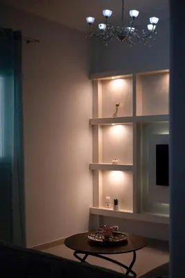 a living room with a table and a chandelier at Cuka apartment 3BD nexto to metro and Piraeus Port in Piraeus
