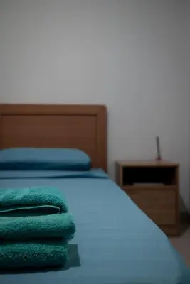a bed with green towels on top of it at Cuka apartment 3BD nexto to metro and Piraeus Port in Piraeus
