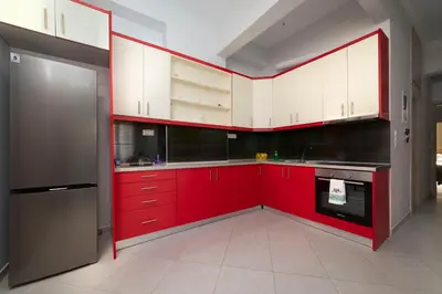 a red kitchen with white cabinets and appliances at Cuka apartment 3BD nexto to metro and Piraeus Port in Piraeus