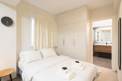 a bedroom with a white bed with two towels at Quiet Studio In The Heart of Athens in Athens