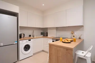 a kitchen with white cabinets and a washer and dryer at Quiet Studio In The Heart of Athens in Athens