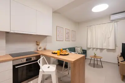 a kitchen with white cabinets and a table with fruit on it at Quiet Studio In The Heart of Athens in Athens