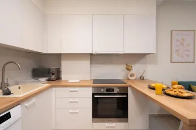 a kitchen with white cabinets and a plate of food on a counter at Quiet Studio In The Heart of Athens in Athens