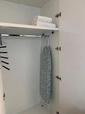 a white closet with a tie on a shelf at Modern Athens Apartment - Close to Metro in Athens