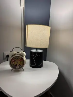 a lamp and an alarm clock sitting on a table at Modern Athens Apartment - Close to Metro in Athens