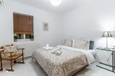 a white bedroom with a bed and a chair at Olympian Zeus - Premium & Luxury Athenian House in Athens