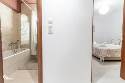 a bathroom with a tub and a bedroom with a bed at Olympian Zeus - Premium & Luxury Athenian House in Athens