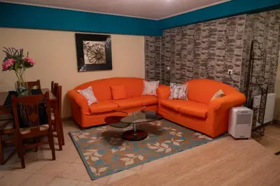 a living room with two orange couches and a table at Apartment Margarita in Athens