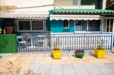 a blue fence in front of a house with flower pots at Apartment Margarita in Athens