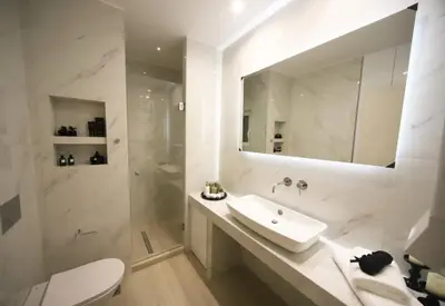 a white bathroom with a sink and a mirror at Apartment Cathrine in Athens