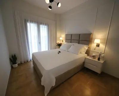 a bedroom with a large white bed and a window at Apartment Cathrine in Athens