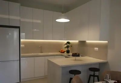 a kitchen with white cabinets and a island with stools at Apartment Cathrine in Athens