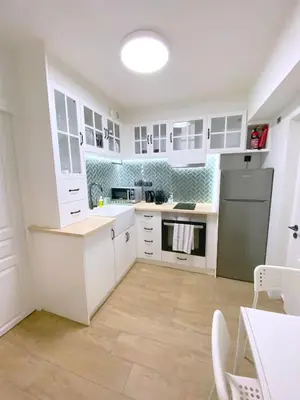 a kitchen with white cabinets and a sink and a refrigerator at MediTerra Stay Athens Park Place in Athens