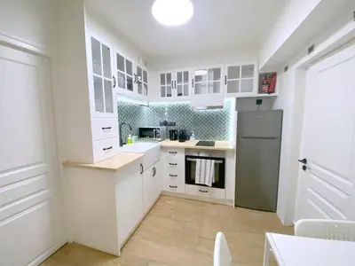 a kitchen with white cabinets and a refrigerator at MediTerra Stay Athens Park Place in Athens