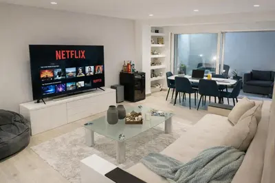 a living room with a couch and a tv and a table at Luxury 2 storey 2bedroom condo with Private Jacuzzi & patio - Athens in Athens