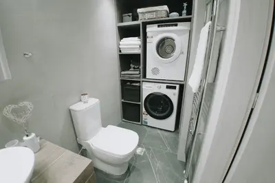 a bathroom with a toilet and a washing machine at Luxury 2 storey 2bedroom condo with Private Jacuzzi & patio - Athens in Athens