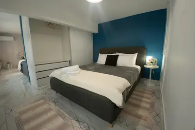 a bedroom with a large bed with a blue wall at Luxury modern chic 1-bedroom apartment Athens City in Athens