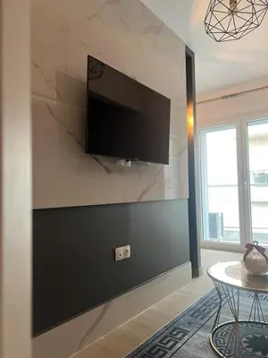 a living room with a flat screen tv on a wall at Modern Athens Escape - Queen Bed & Metro Access in Athens