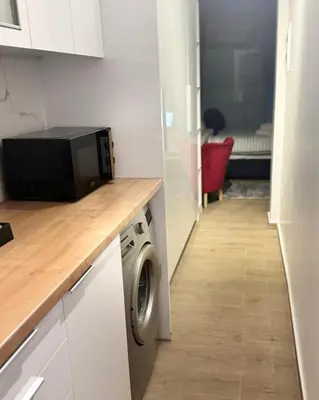 a kitchen with a microwave and a washing machine at Modern Athens Escape - Queen Bed & Metro Access in Athens