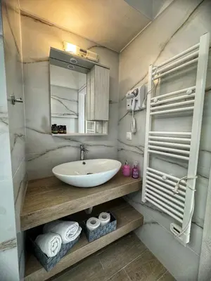 a bathroom with a sink and a mirror and towels at Modern Athens Escape - Queen Bed & Metro Access in Athens