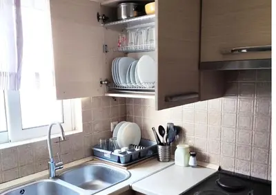 a kitchen sink with plates and utensils on a shelf at Apartment, Piraeus in Piraeus